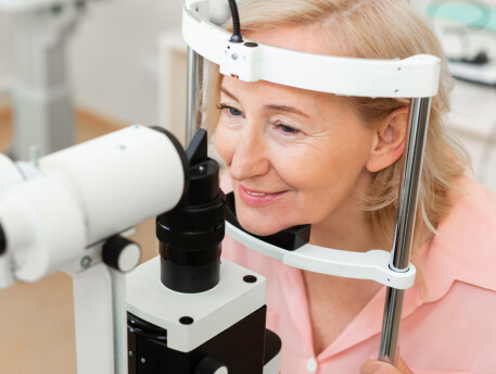 elderly woman smiling while having eye exam