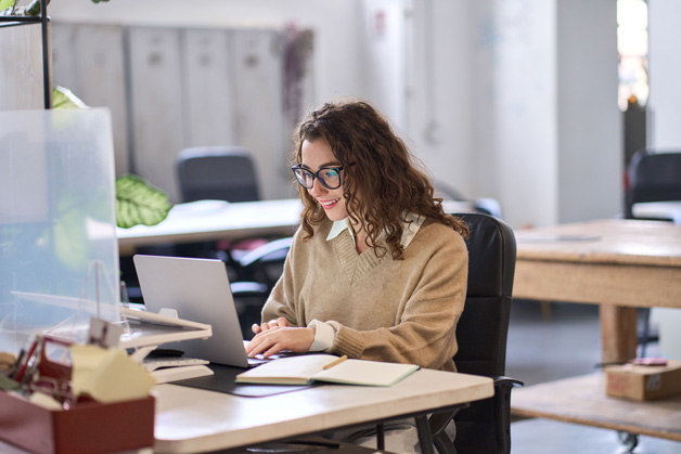 woman working on her computer while wearing her glasses