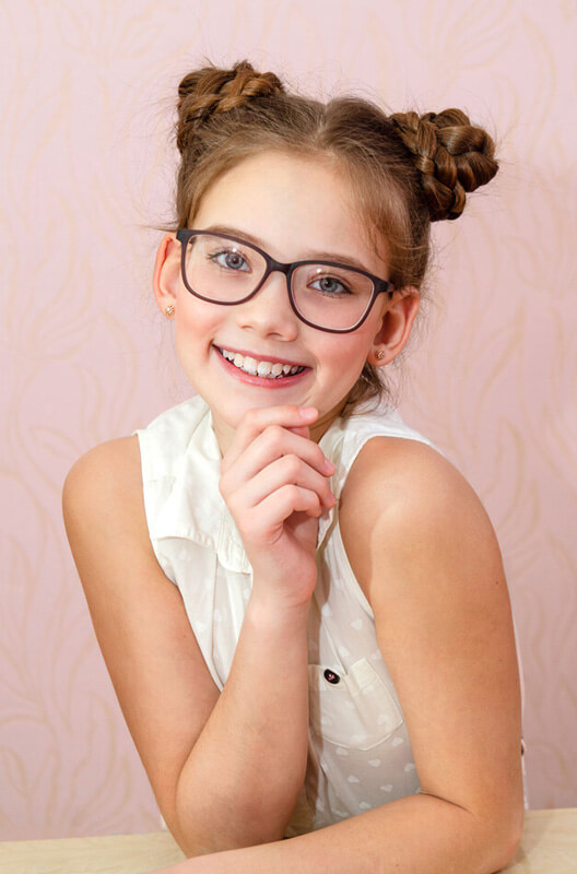 cute young girl smiling with her new eyeglasses